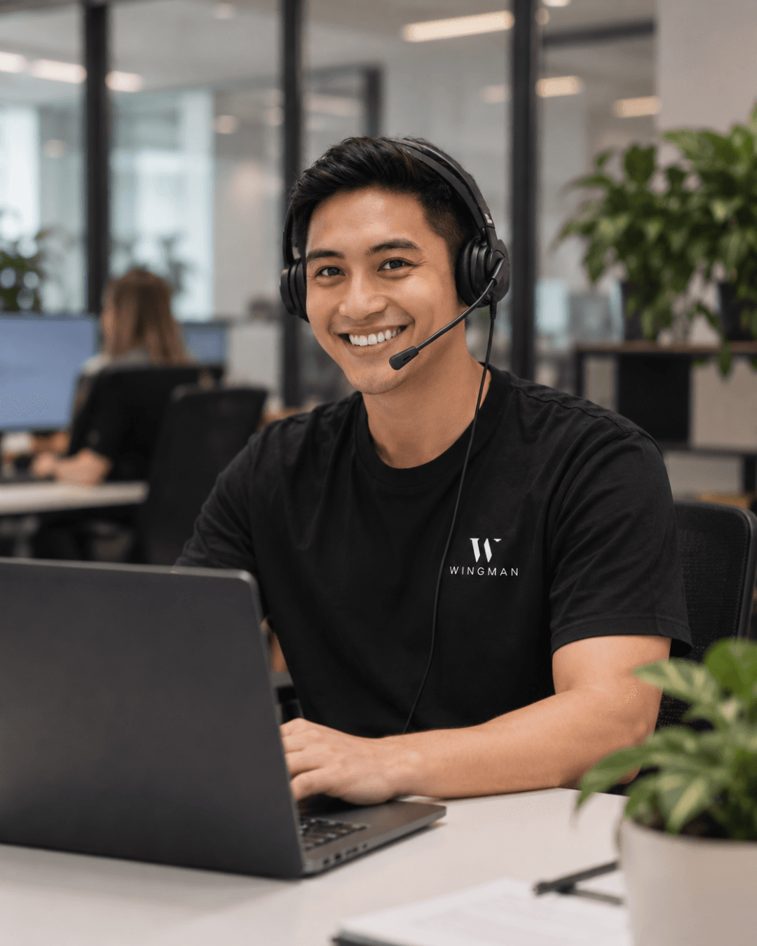A Wingman Remote Professional working at a laptop in a modern office