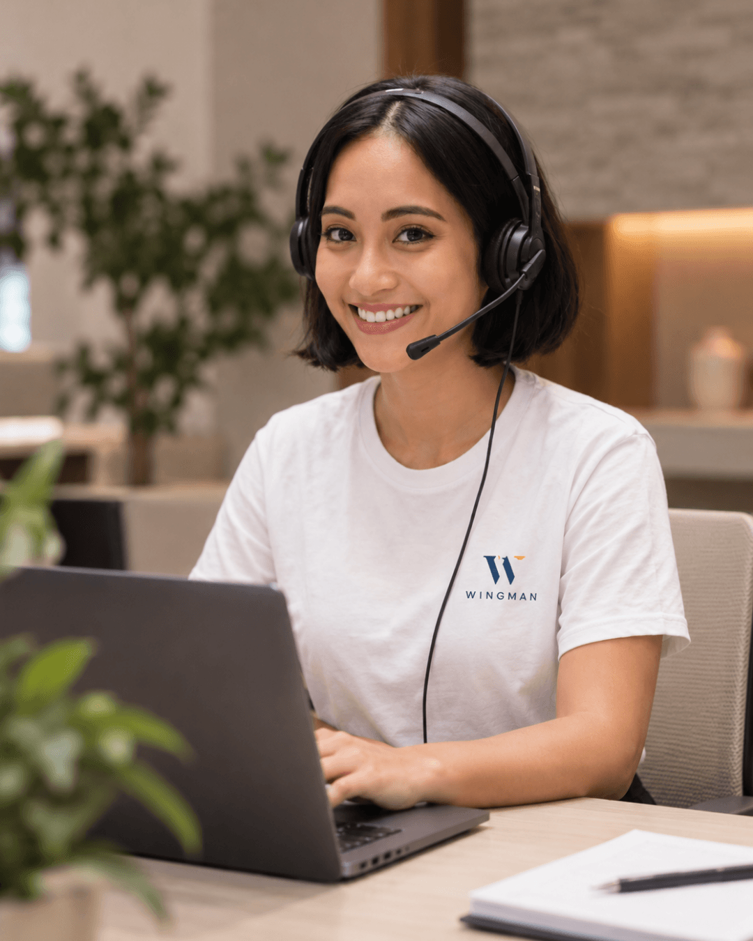 A Wingman Remote Professional smiling at her desk